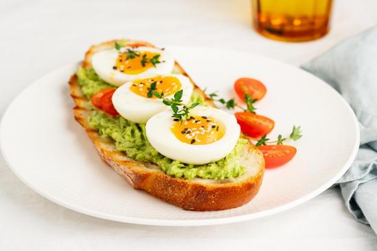 Avocado toast with toasted bread soft-boiled eggs with tomat